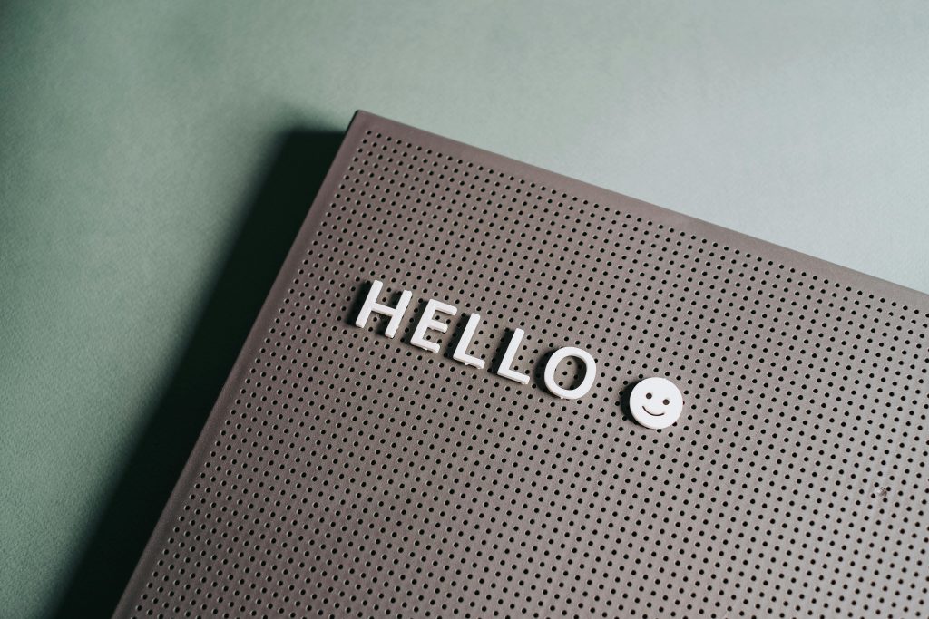 Pegboard with the word 'hello' spelled out in white letters and a smiley face.